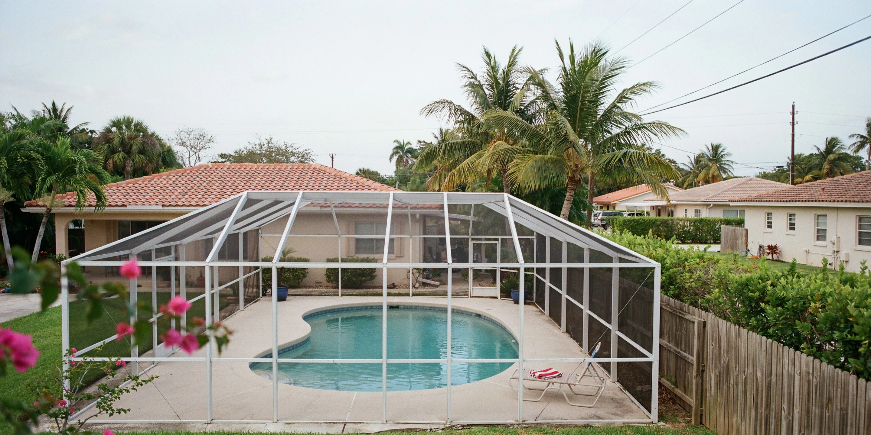 First-generation pool cage over a kidney-shaped pool in Bayshore Gardens, FL